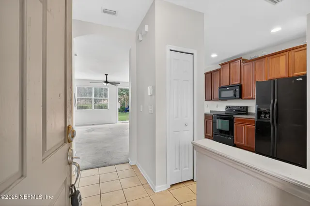 a kitchen with granite countertop a refrigerator and a stove top oven