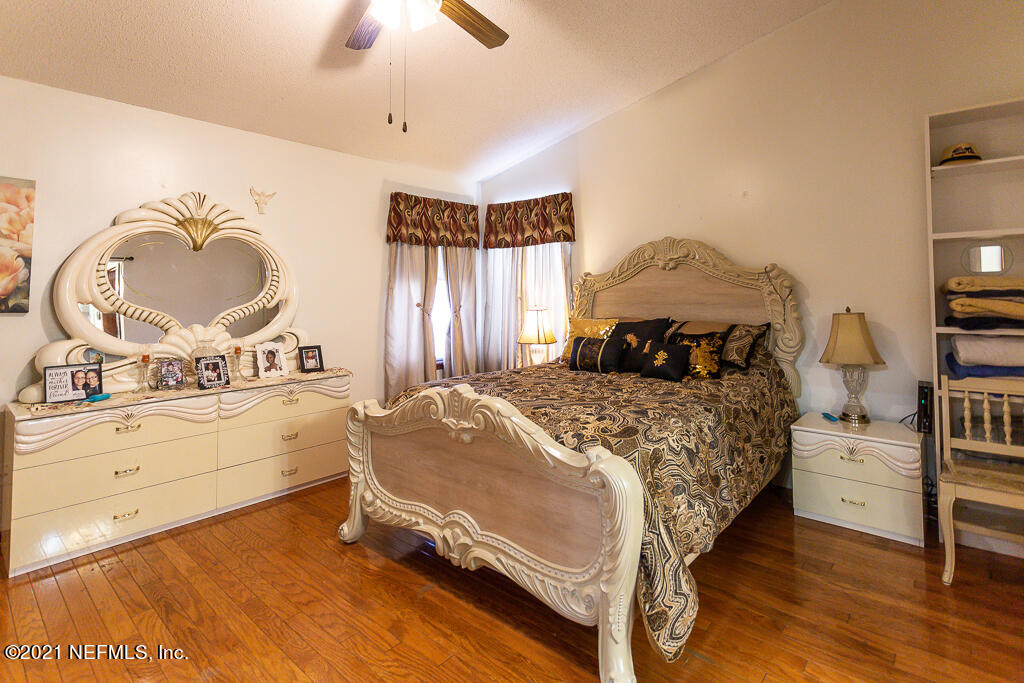 2450 Wattle Tree Road East Jacksonville, FL 32246 - Photo 16 of 24 a bedroom with a bed and a chandelier