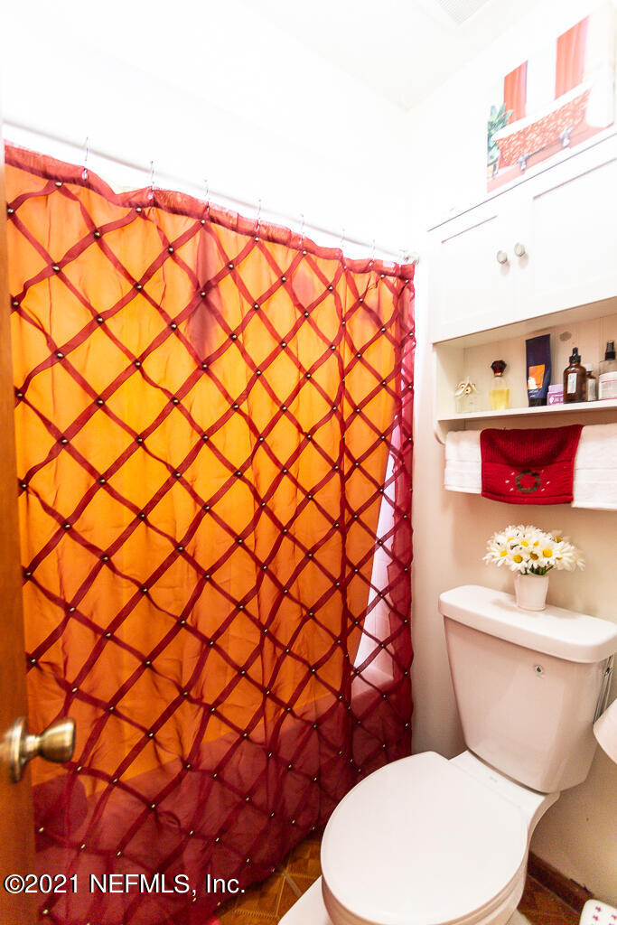 2450 Wattle Tree Road East Jacksonville, FL 32246 - Photo 19 of 24 a white toilet sitting next to a shower curtain