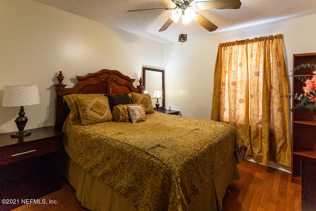 2450 Wattle Tree Road East Jacksonville, FL 32246 - Photo 5 of 24 a bedroom with a bed and a chandelier