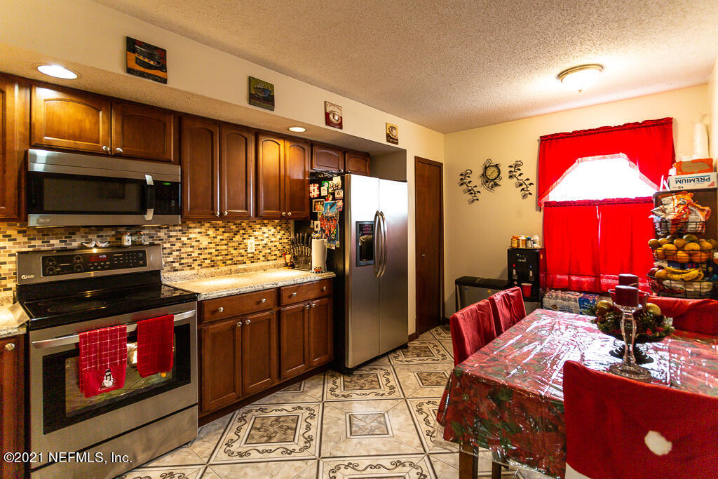 2450 Wattle Tree Road East Jacksonville, FL 32246 - Photo 10 of 24 a kitchen with stainless steel appliances granite countertop a stove refrigerator and microwave