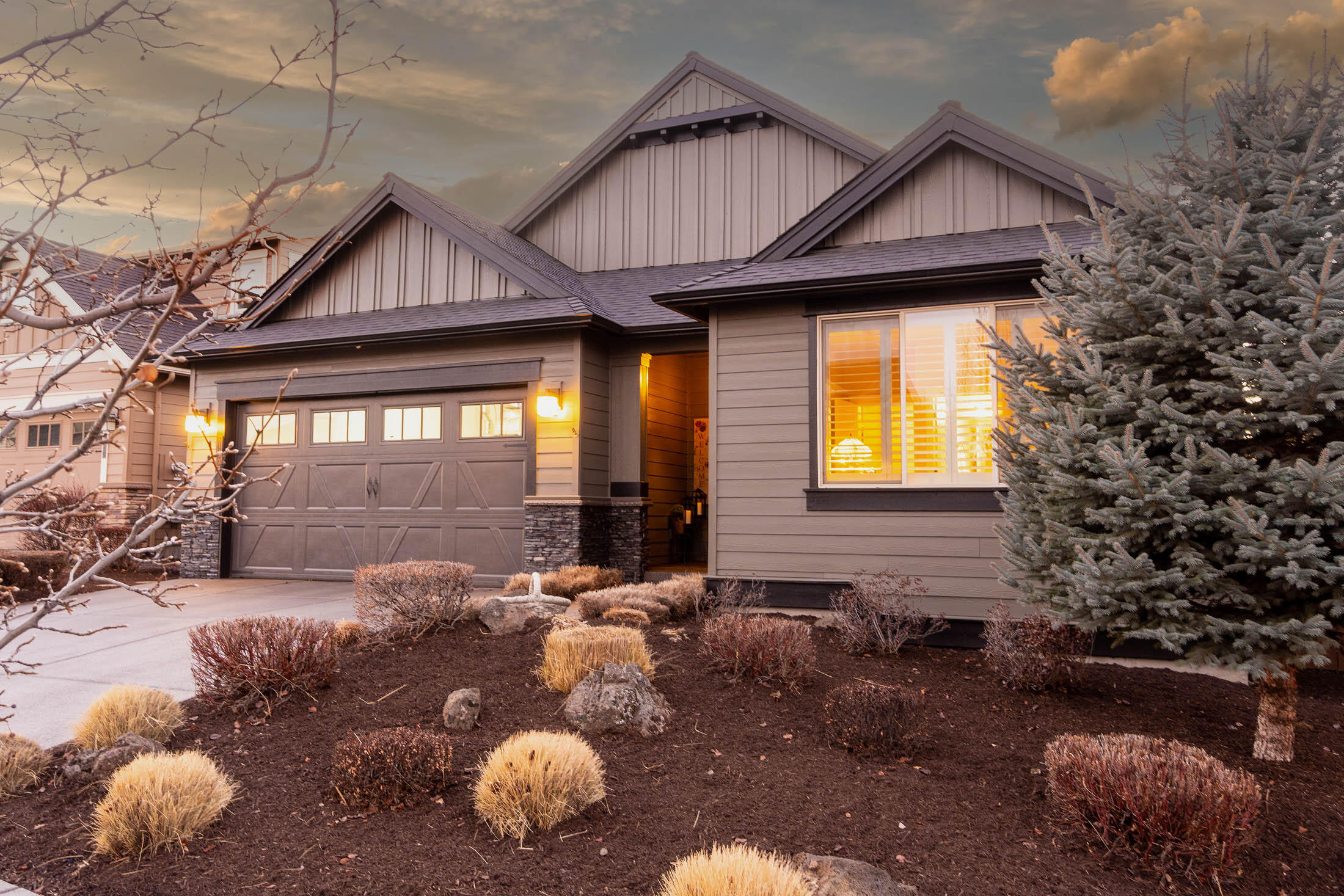 61129 Manhae Loop Bend, OR 97702 - Photo 1 of 44 Front exterior has stone masonry accents and exposed aggregate driveway and walk to covered front porch.