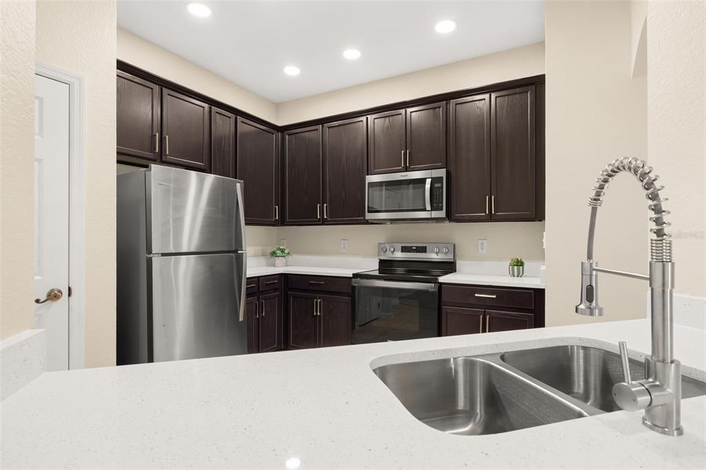 3001 Greystone Loop, Unit 106 Kissimmee, FL 34741 - Photo 3 of 27 a kitchen with a refrigerator sink and cabinets