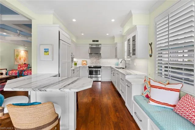 a large kitchen with stainless steel appliances kitchen island granite countertop a large counter top and white cabinets