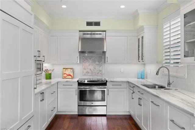 a kitchen with white cabinets and white appliances