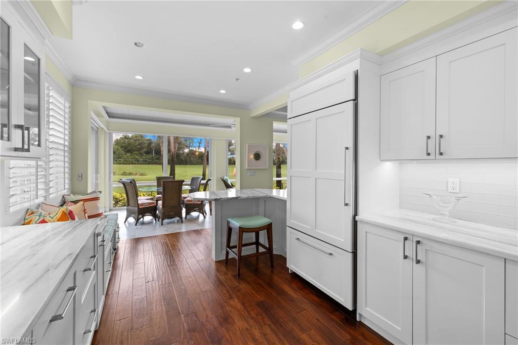 2120 Aberdeen Lane, Unit 101 Naples, FL 34109 - Photo 21 of 47 a kitchen with stainless steel appliances a refrigerator a table and chairs