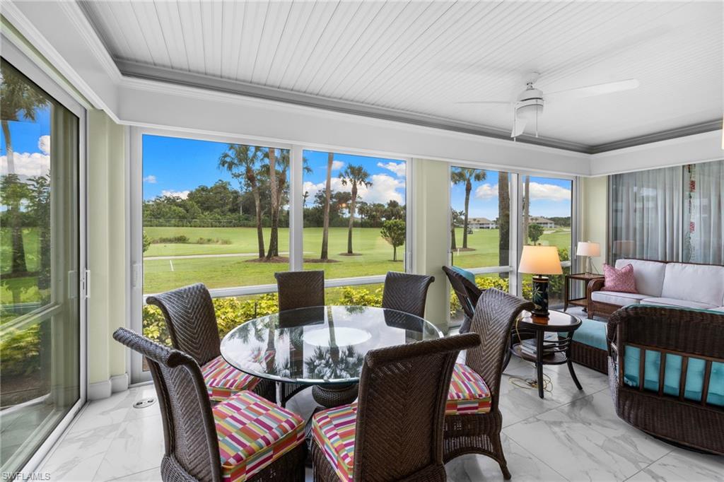 2120 Aberdeen Lane, Unit 101 Naples, FL 34109 - Photo 25 of 47 a dining room with furniture a large window and a yard
