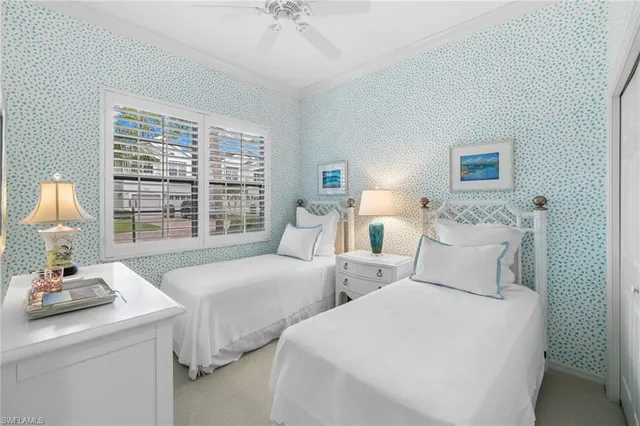 a bedroom with two beds and a large window