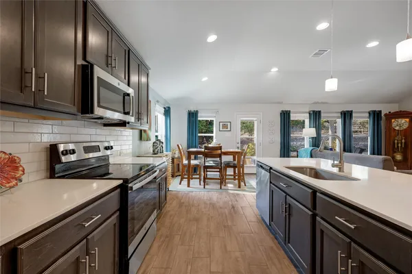 a kitchen with stainless steel appliances a sink stove and cabinets