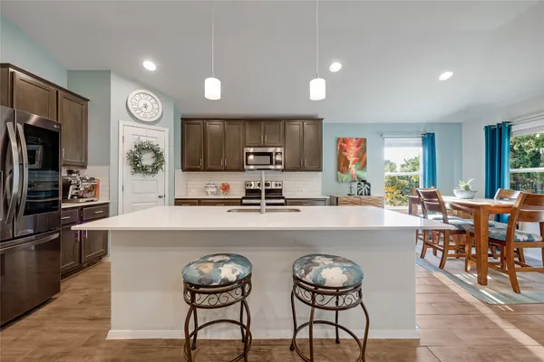 a large kitchen with a table and chairs