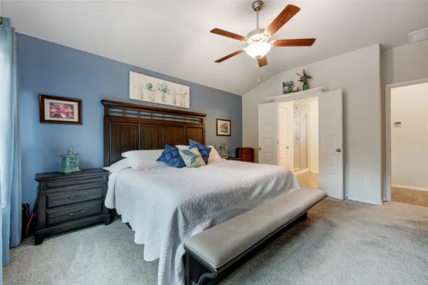 a bedroom with a bed and a ceiling fan