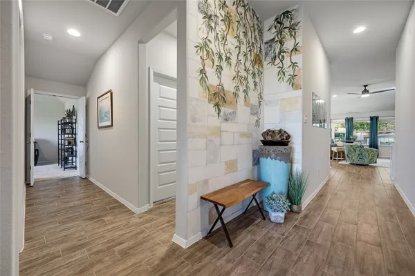 a view of a hallway with wooden floor and a living room