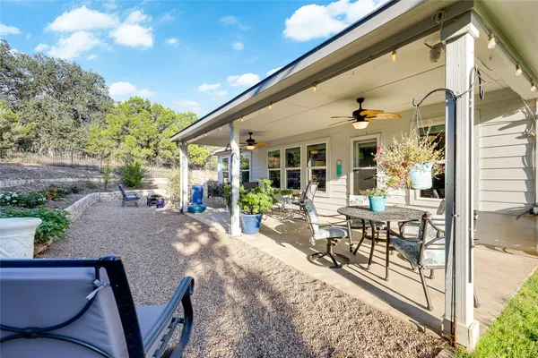 a view of a patio with couches table and chairs and potted plants