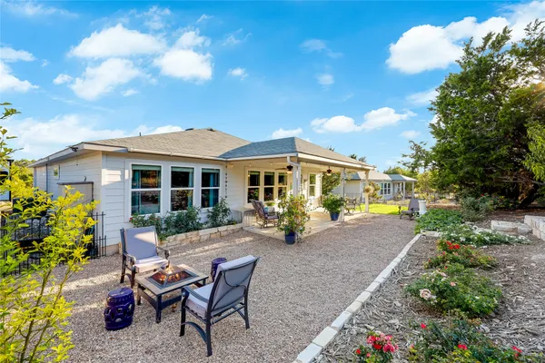 a view of a house with backyard sitting area and garden