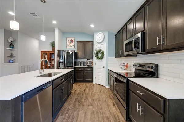 a kitchen with stainless steel appliances granite countertop wooden cabinets sink and stove