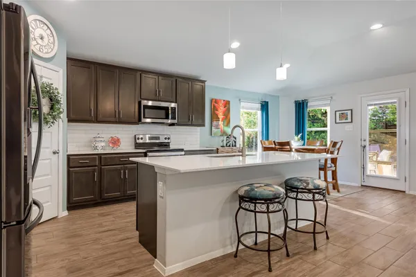 a kitchen with granite countertop a stove top oven microwave and cabinets