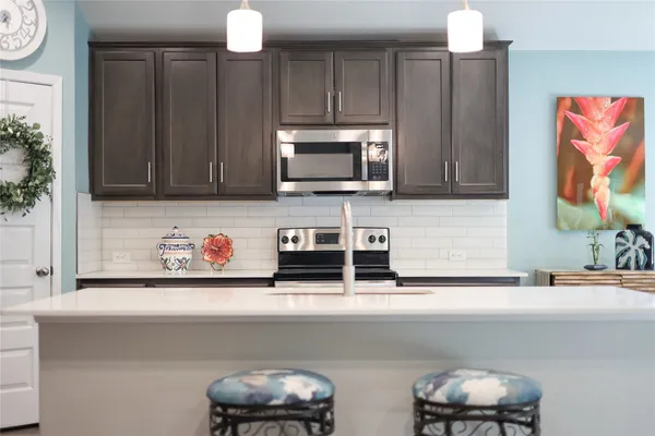 a kitchen with stainless steel appliances a microwave a sink and cabinets