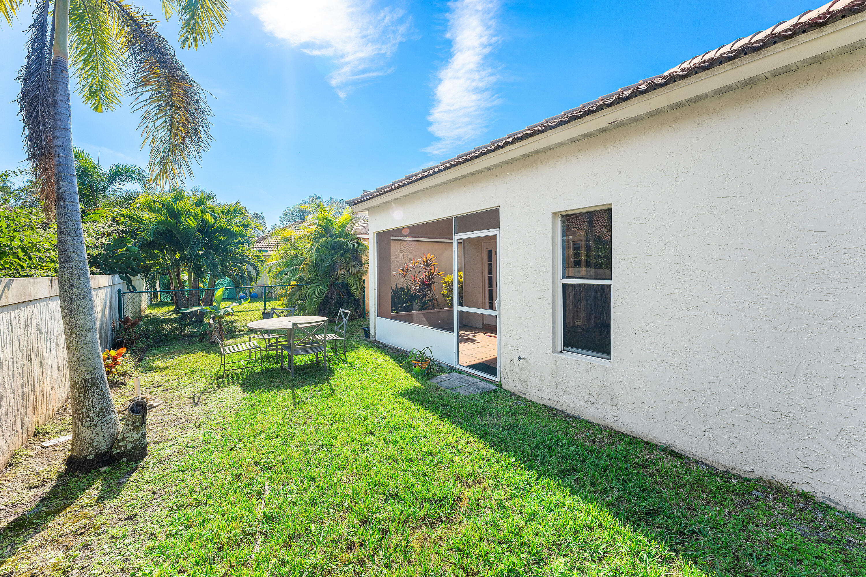 2100 Bonisle Circle Riviera Beach, FL 33418 - Photo 19 of 24 a view of a chair and tables in the back yard of the house