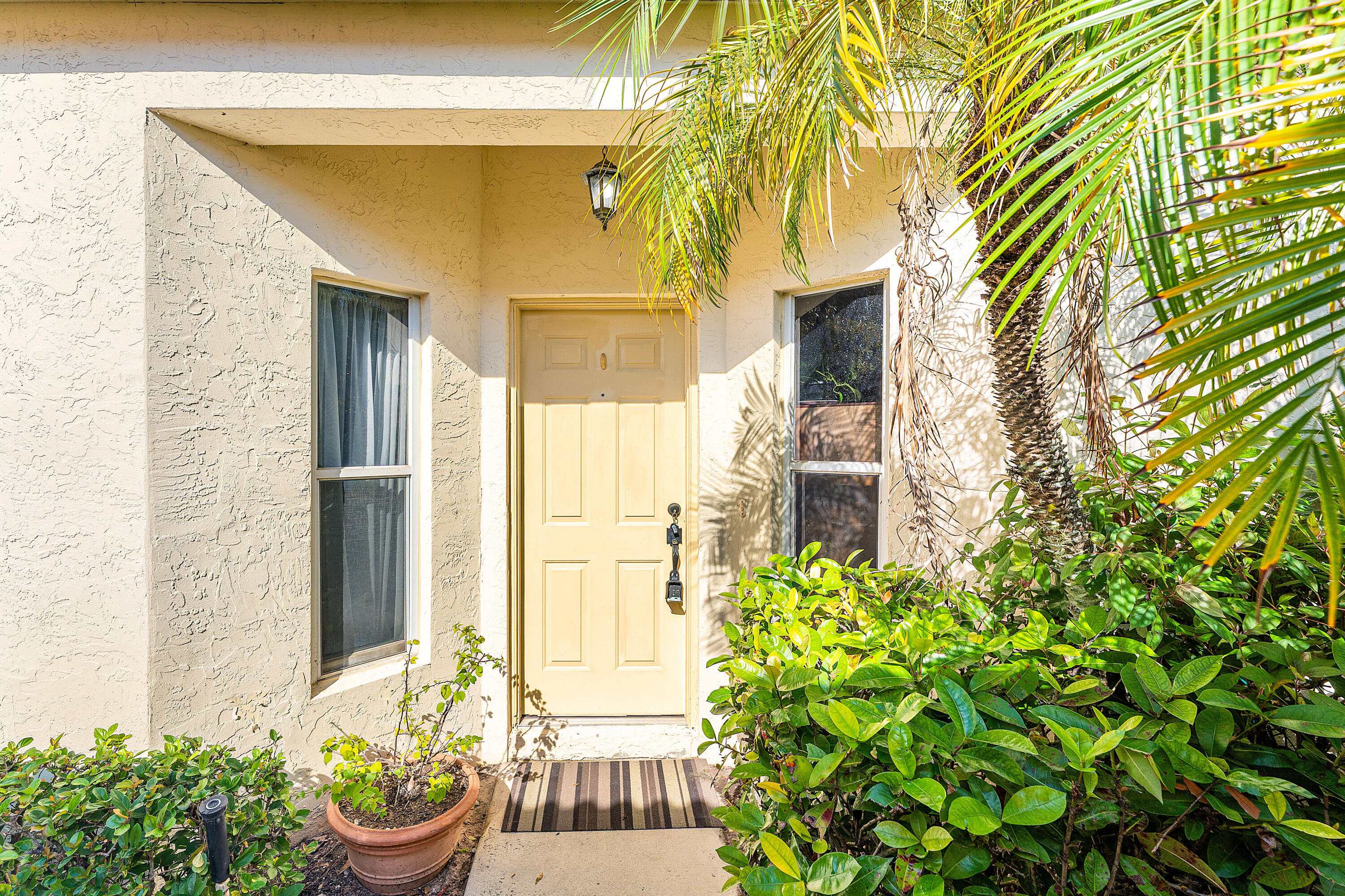 2100 Bonisle Circle Riviera Beach, FL 33418 - Photo 2 of 24 a front view of a house with a garden