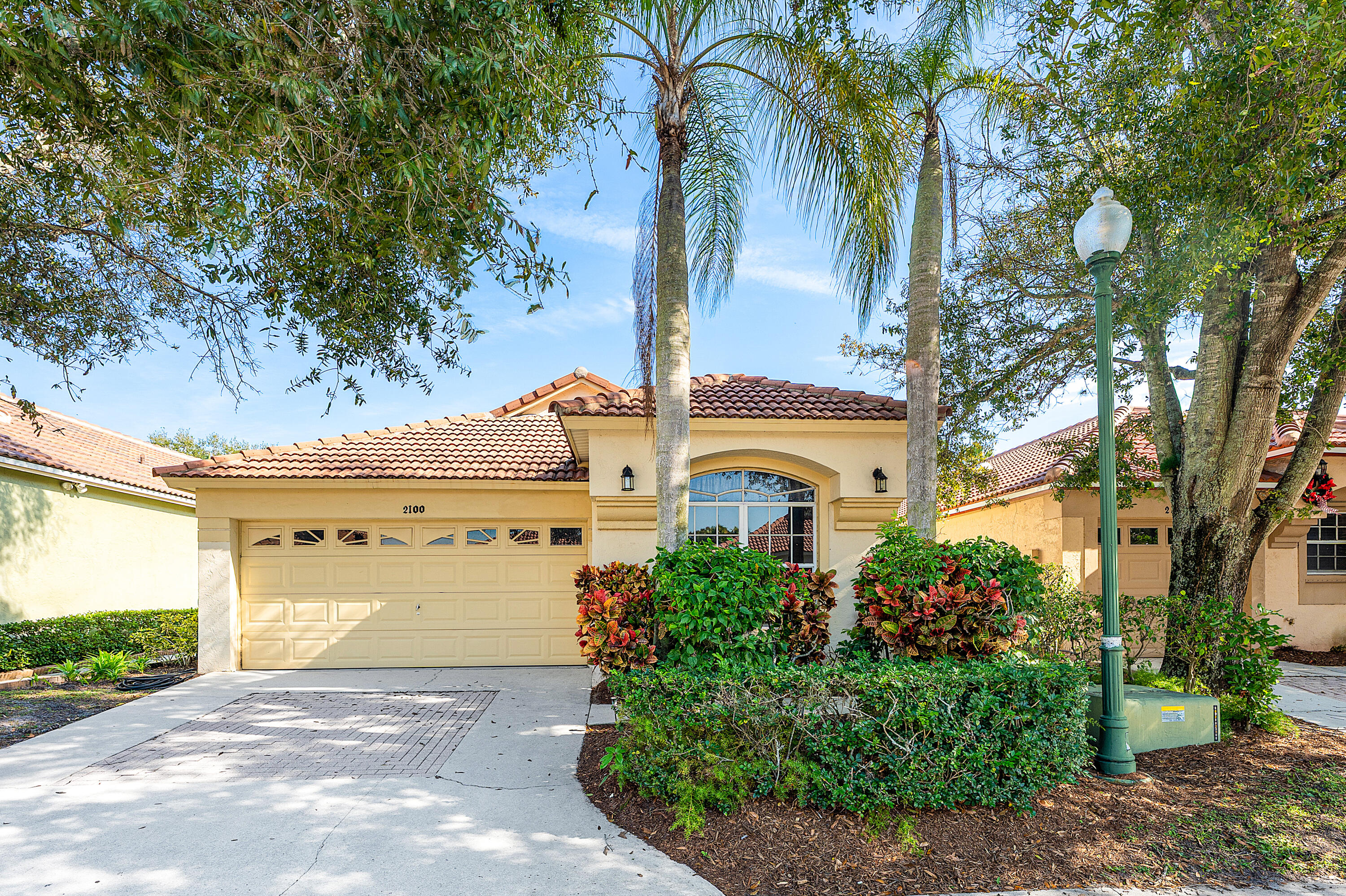 2100 Bonisle Circle Riviera Beach, FL 33418 - Photo 22 of 24 a front view of a house with a yard and garage