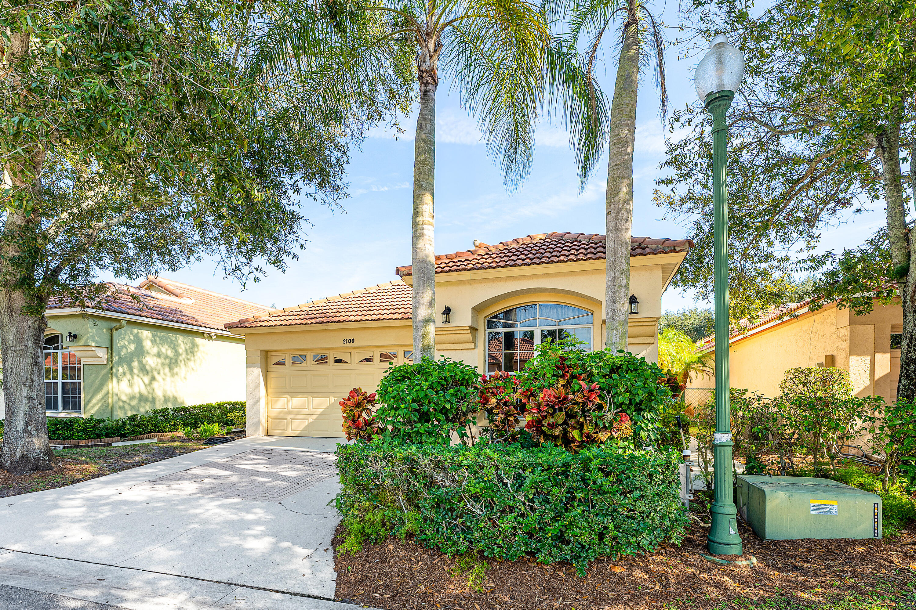 2100 Bonisle Circle Riviera Beach, FL 33418 - Photo 23 of 24 a front view of a house with a garden