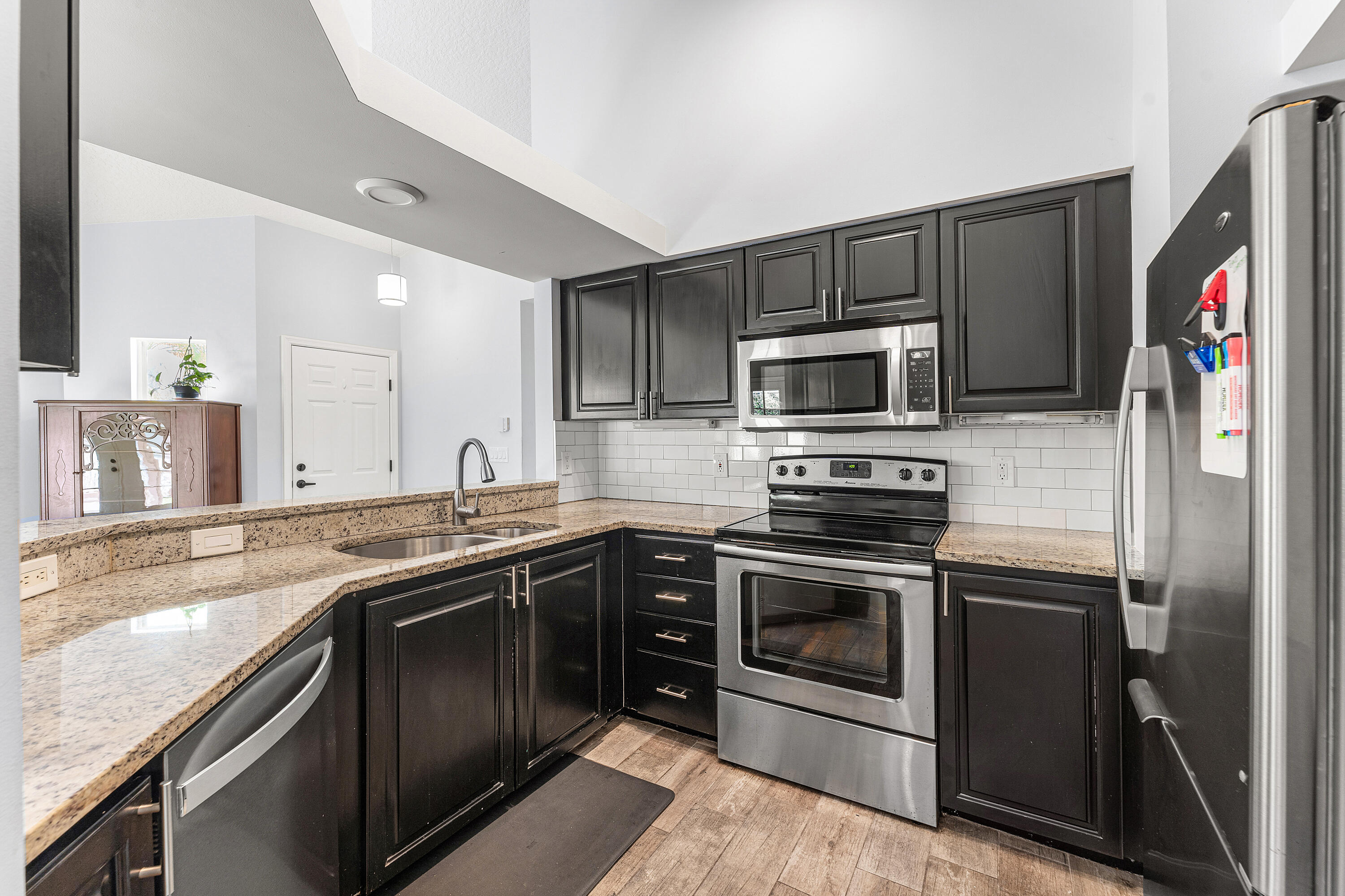 2100 Bonisle Circle Riviera Beach, FL 33418 - Photo 8 of 24 a kitchen with stainless steel appliances granite countertop a stove sink and microwave