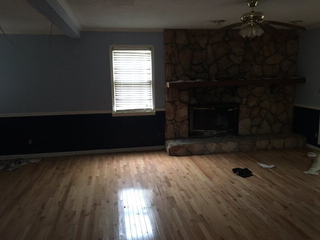 3334 Hamlin Road Lizella, GA 31052 - Photo 5 of 11 an empty room with wooden floor and fireplace