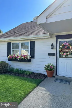 a front view of a house with a yard and potted plants