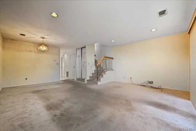 an empty room with an entryway and chandelier