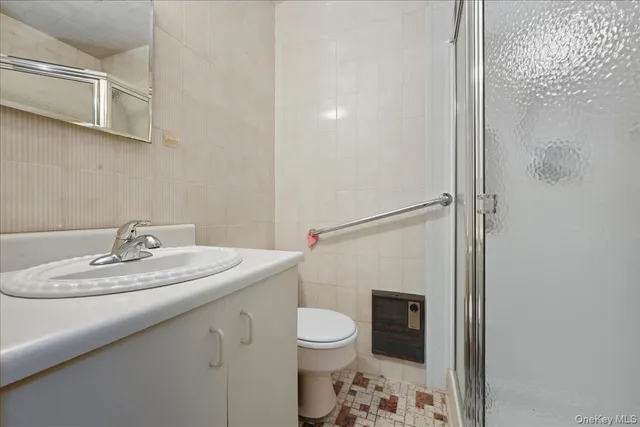 a bathroom with a granite countertop sink a toilet and shower