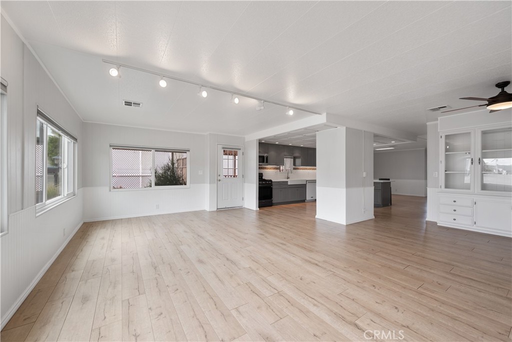 1675 Los Osos Valley Road, Unit 135 Los Osos, CA 93402 - Photo 12 of 38 a view of empty room with wooden floor and a kitchen
