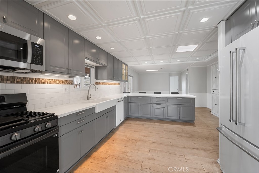 1675 Los Osos Valley Road, Unit 135 Los Osos, CA 93402 - Photo 14 of 38 a large kitchen with stainless steel appliances wooden cabinets and a stove top oven