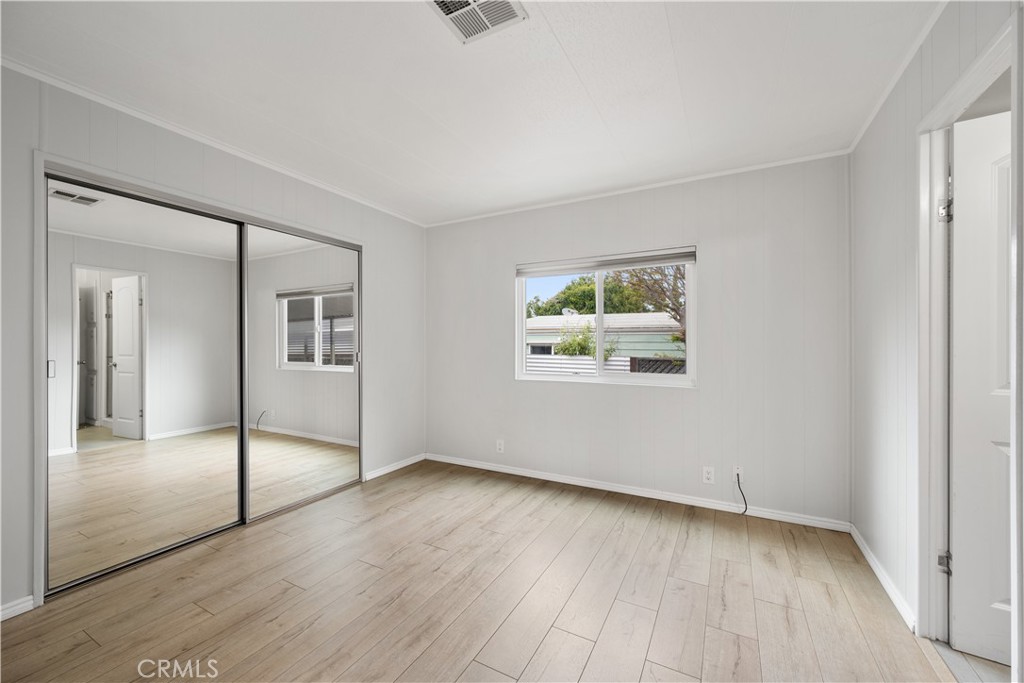 1675 Los Osos Valley Road, Unit 135 Los Osos, CA 93402 - Photo 25 of 38 an empty room with wooden floor and windows
