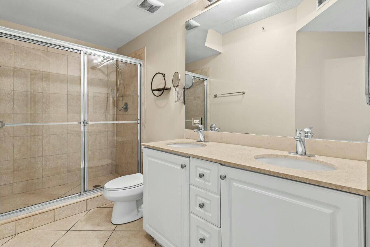 1690 Renaissance Commons Boulevard, Unit 1125 Boynton Beach, FL 33426 - Photo 15 of 37 a bathroom with a granite countertop sink a toilet and a shower