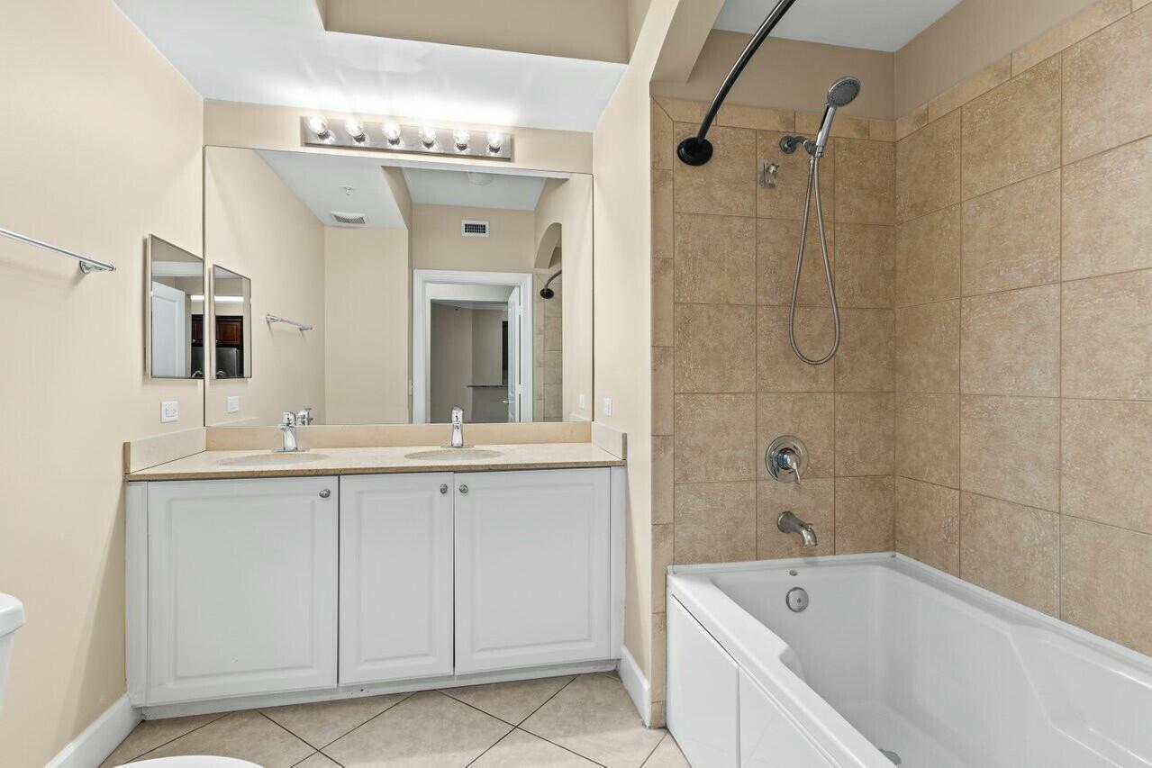 1690 Renaissance Commons Boulevard, Unit 1125 Boynton Beach, FL 33426 - Photo 18 of 37 a bathroom with a tub a sink and mirror