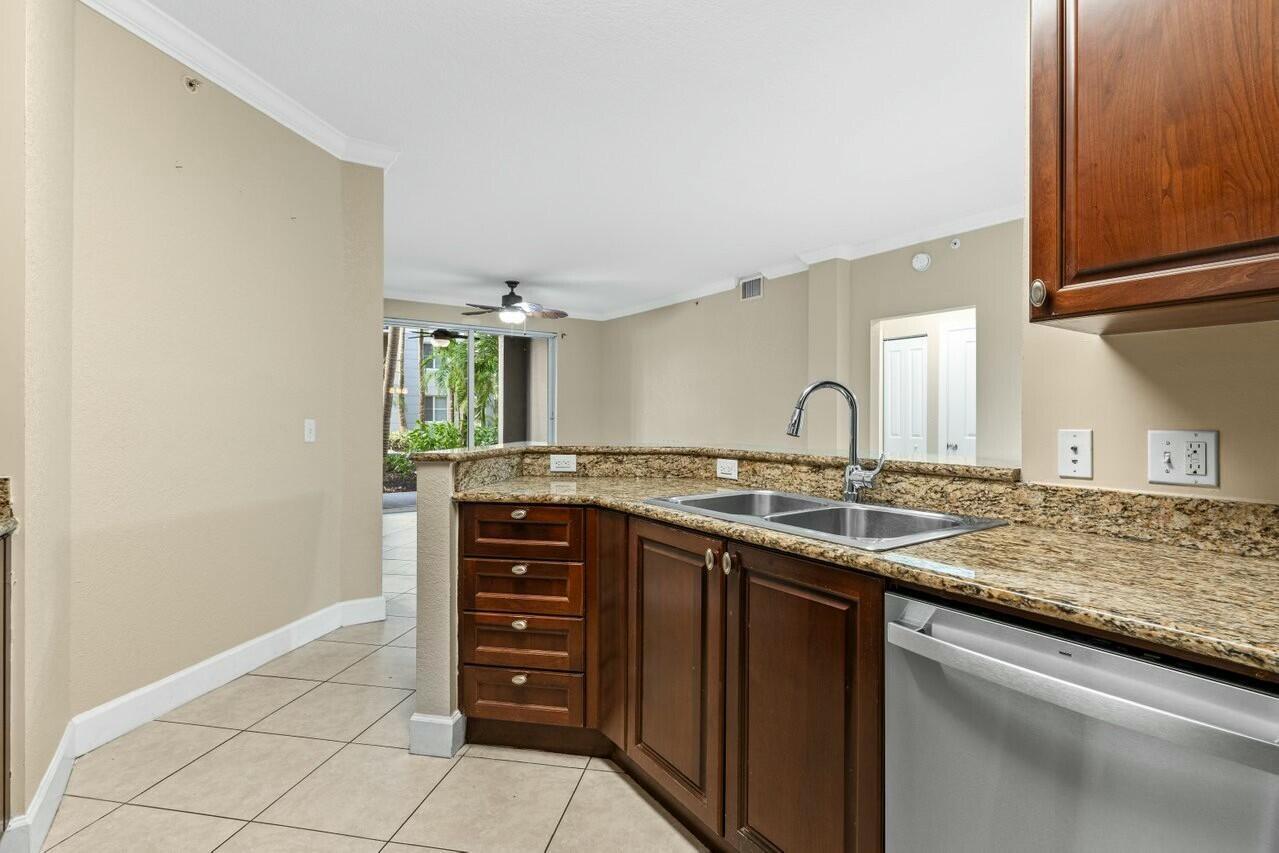 1690 Renaissance Commons Boulevard, Unit 1125 Boynton Beach, FL 33426 - Photo 4 of 37 a bathroom with a granite countertop sink and a mirror