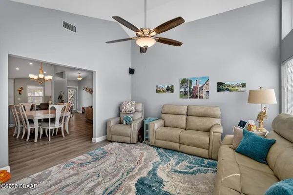 a living room with furniture and a dining table with wooden floor