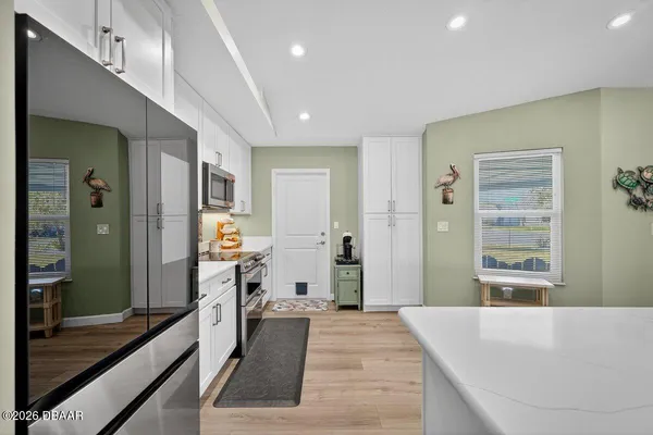 a large living room with stainless steel appliances kitchen island granite countertop furniture and a large window