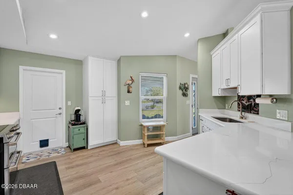 a view of a kitchen with refrigerator and window