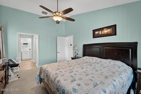 a bedroom with a large bed and a chandelier