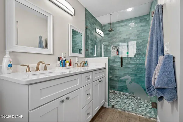 a bathroom with a shower sink and mirror