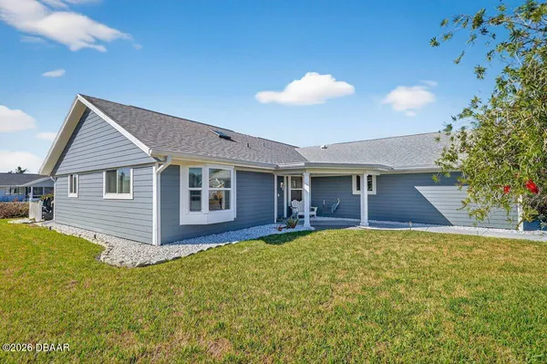a front view of house with yard and trees in the background