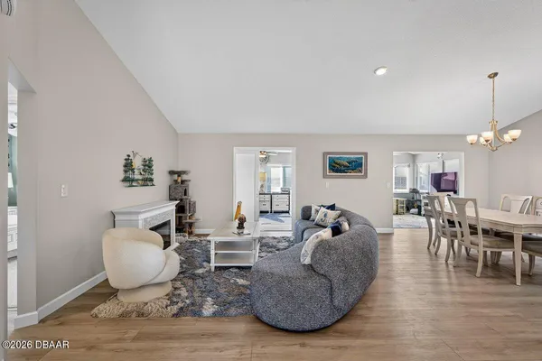 a living room with furniture a dining table and a chandelier