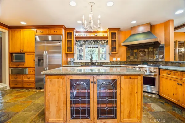 a kitchen with stainless steel appliances granite countertop table chairs sink and cabinets