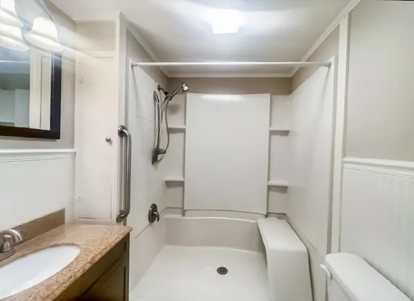 a bathroom with a granite countertop tub sink and mirror