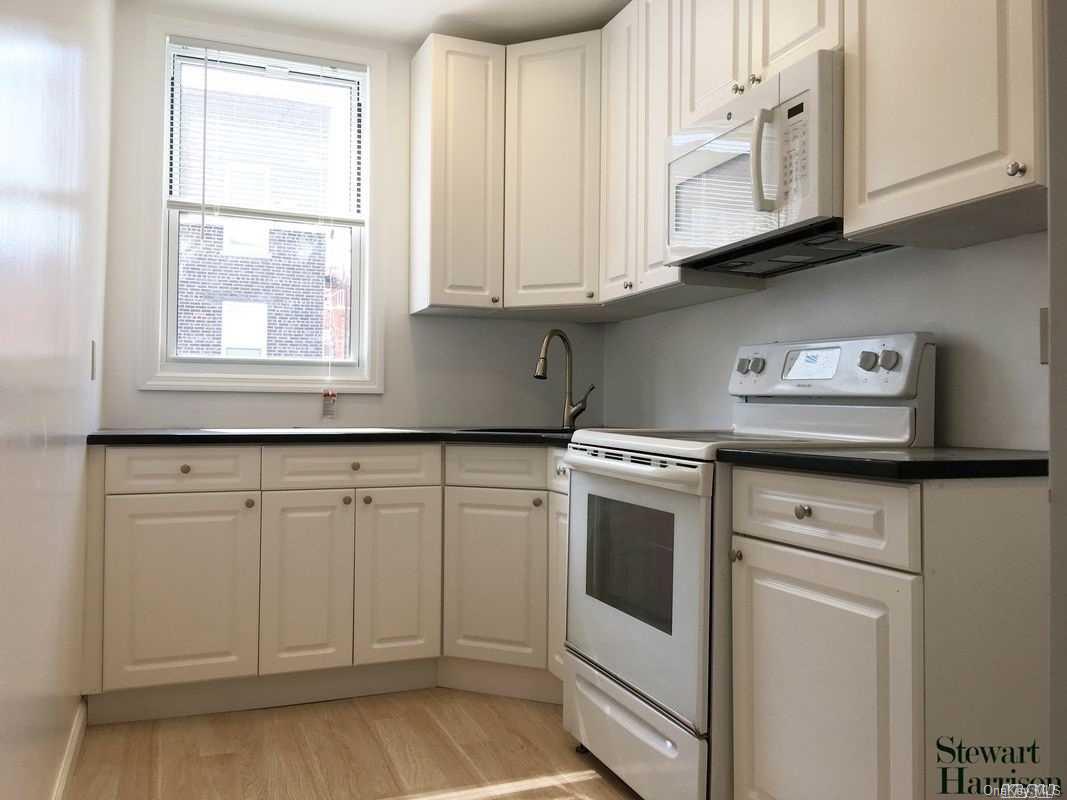 a kitchen with white cabinets and white appliances