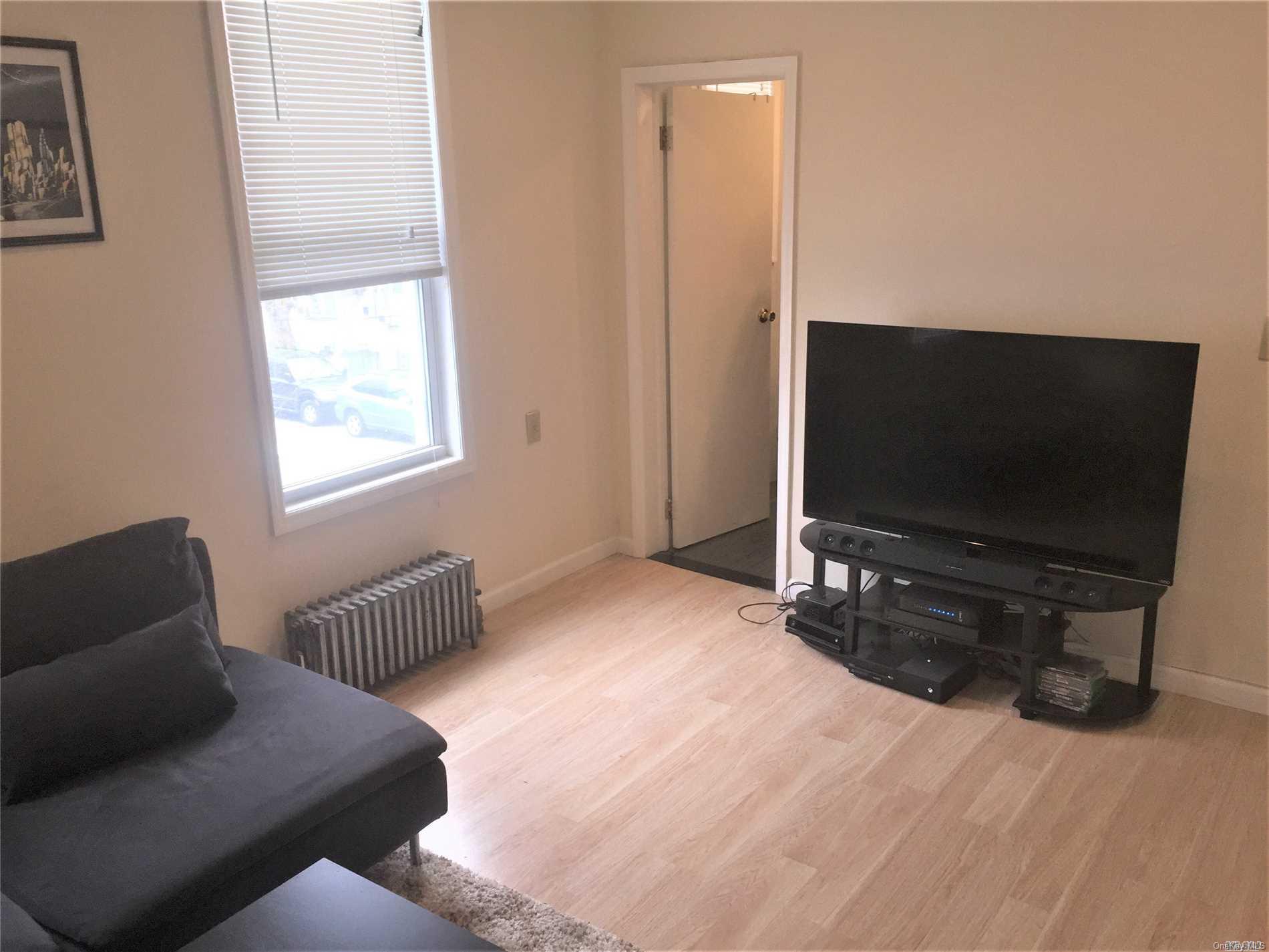 52-05 35th Street, Unit 2 Queens, NY 11101 - Photo 14 of 20 a bedroom with furniture and a flat screen tv
