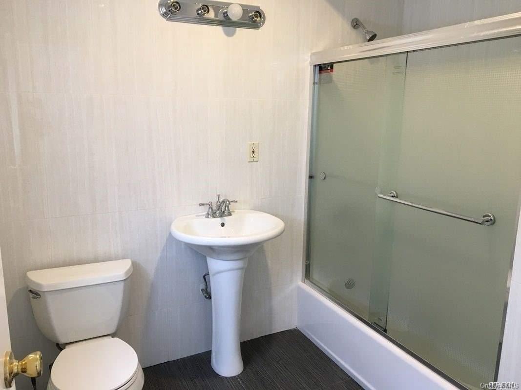 52-05 35th Street, Unit 2 Queens, NY 11101 - Photo 17 of 20 a bathroom with a sink toilet and shower