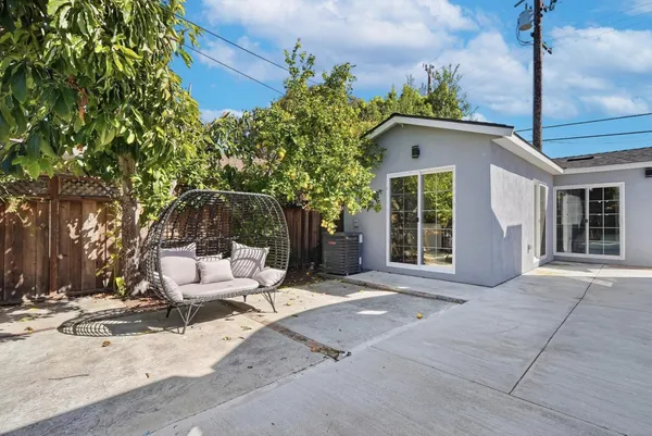 a view of a house with backyard and sitting area