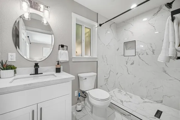 a bathroom with a sink a toilet and a mirror